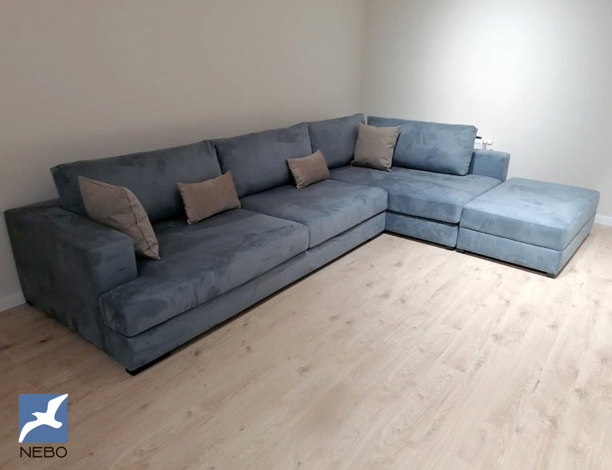 Большой угловой диван в светлой серо-синей  обивке из флока с серыми подушками с возможностью гостевой раскладки