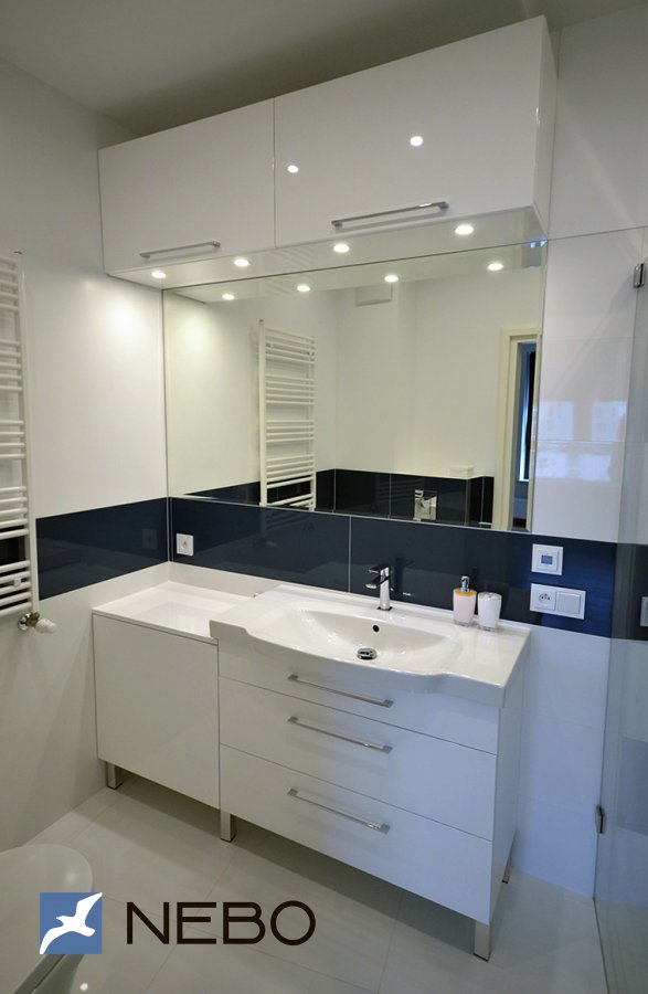 Белая мебель в ванную с напольной тумбой из крашенного МДФ под умывальник и навесными распашными шкафами над зеркалом