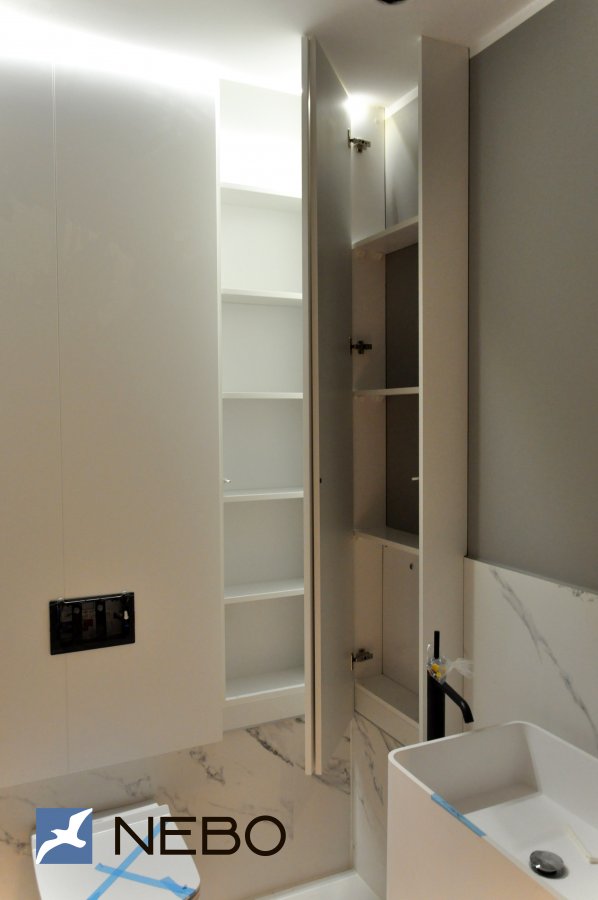 Мебельная зашивка сантехнической зоны с встроенной кнопкой спуска и открывающимися от нажатия шкафчиками справа