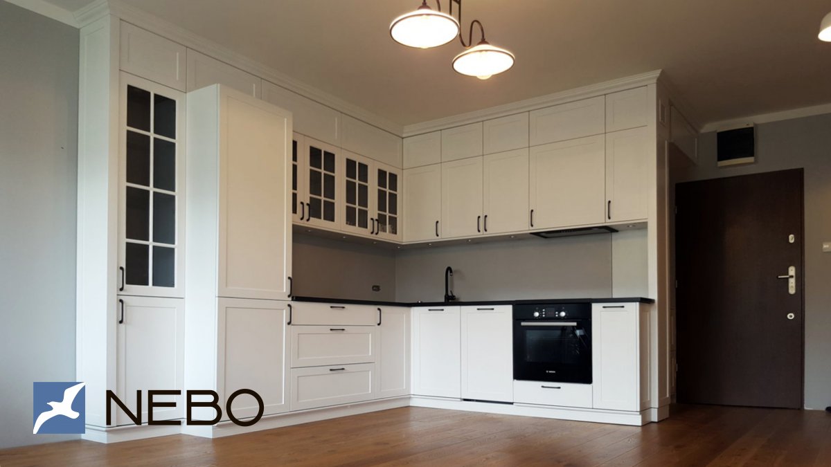 Белая кухня до потолка со встроенным холодильником и шкафами-витринами