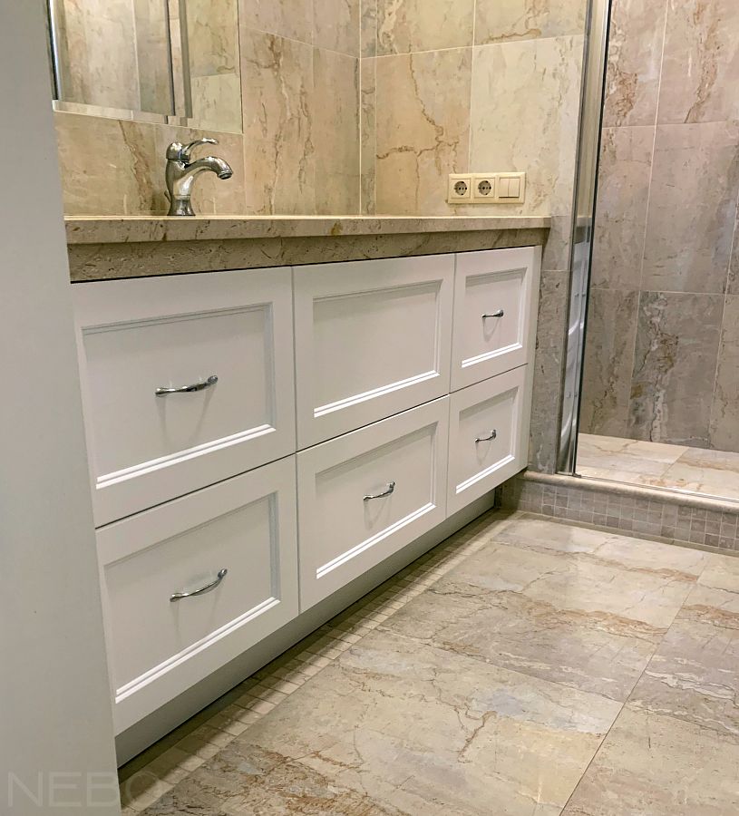 Встроенная белая тумба для ванной с классическими фрезерованными фасадами и ручками-скобами