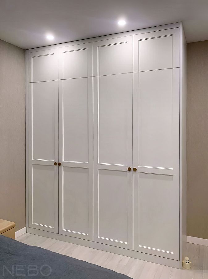 Белый шкаф с фрезеровками на распашных дверях до потолка в спальне