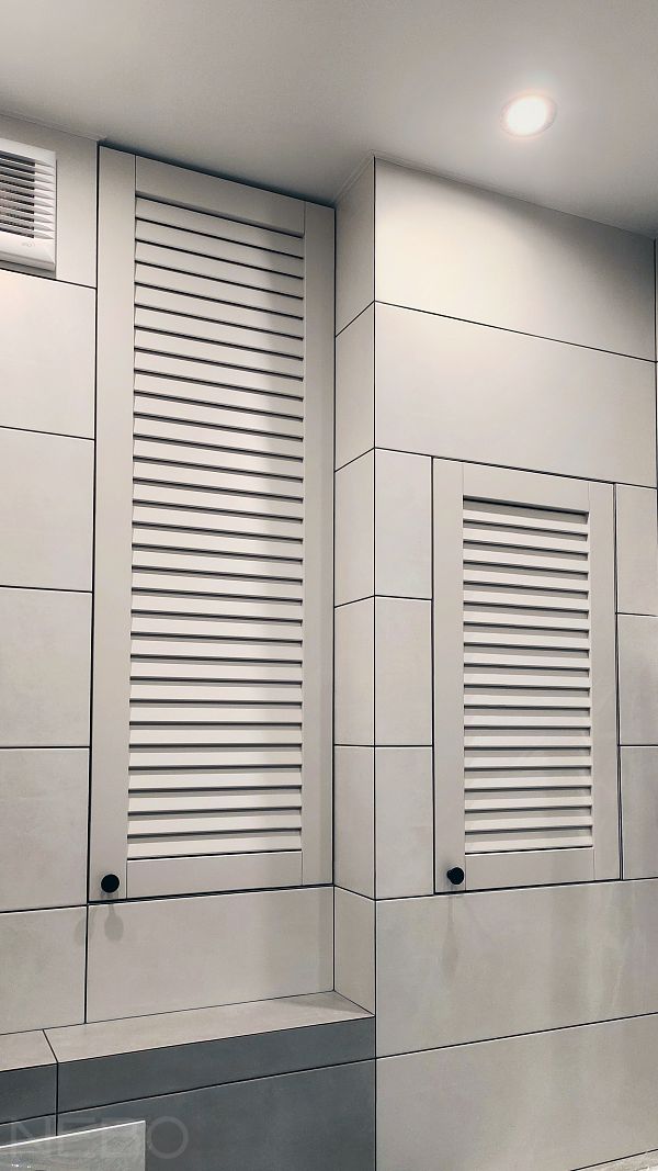 Встроенный шкаф и дверца сантехнического люка с жалюзийными фасадами в туалете над инсталляцией