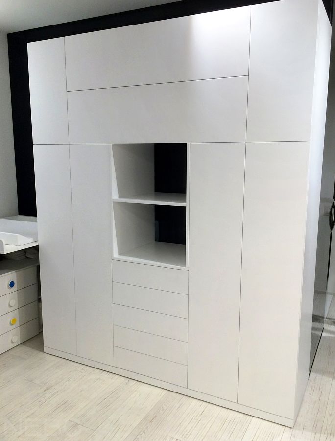 Белый шкаф в детскую с дверцами, выдвижными ящиками и открытой нишей по центру 