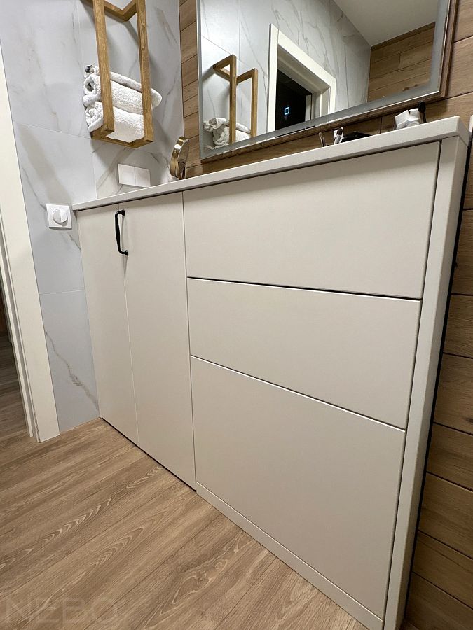 Узкая клиновидная тумба со столешницей без раковины в углу ванной для косметических процедур