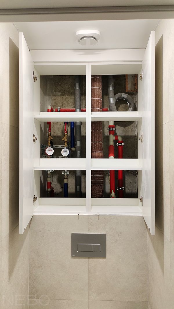 Белые распашные дверцы над инсталляцией в туалете для удобного доступа к коммуникациям и счетчикам