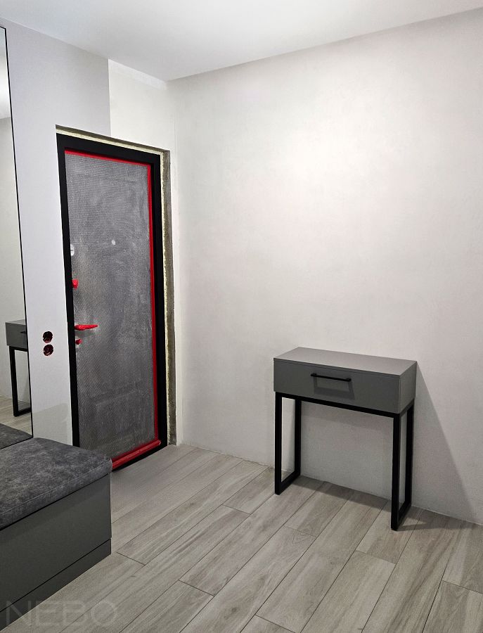 Серый консольный столик на черном металлическом основании в прихожую комнату