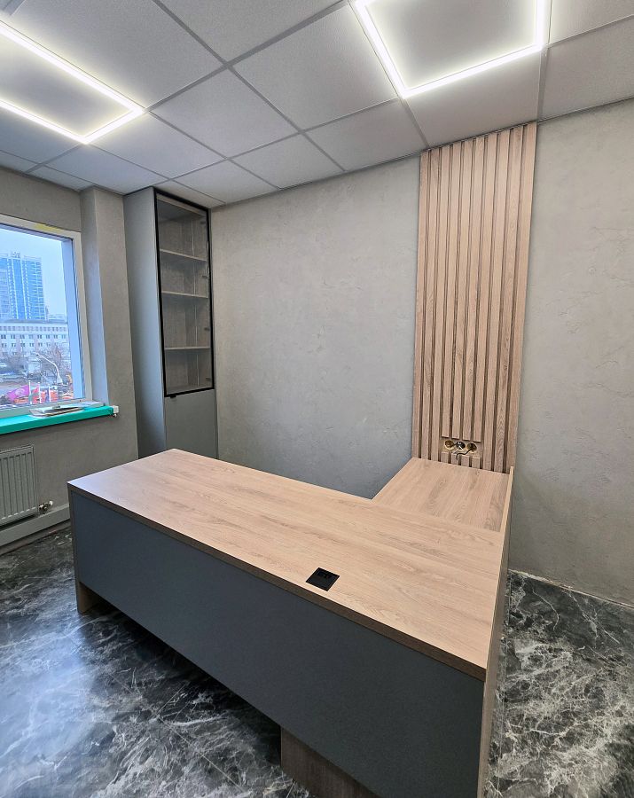 Большой угловой компьютерный стол с рейками на стене в офис