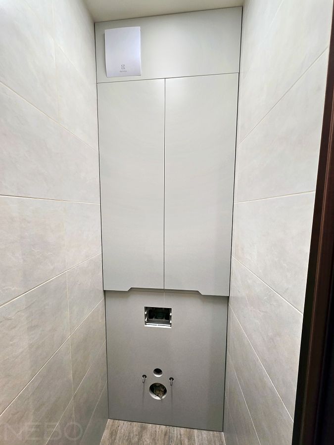 Серая зашивка стены с инсталляцией из крашеного МДФ с распашными дверцами в туалете