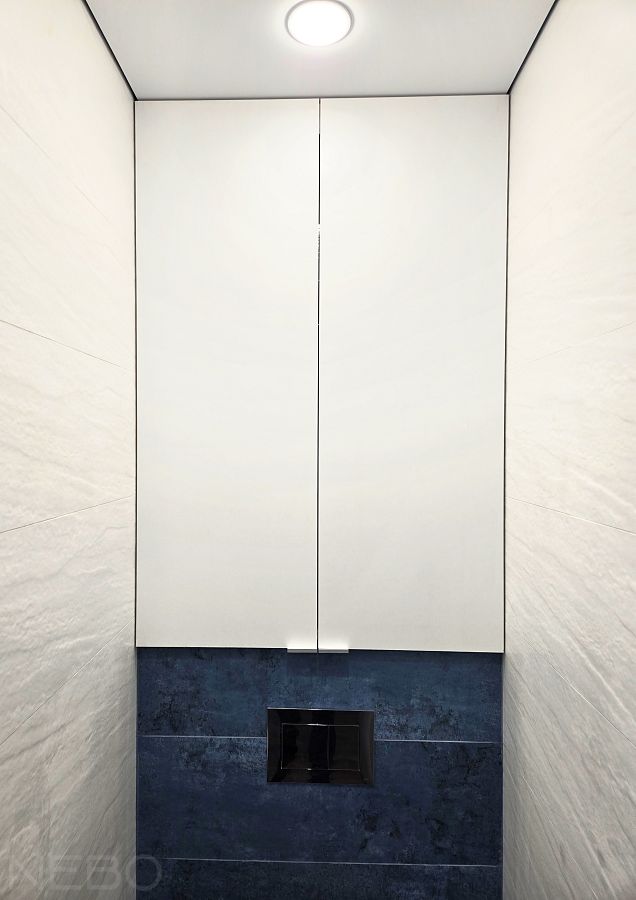 Белые дверцы до потолка над инсталляцией в туалете