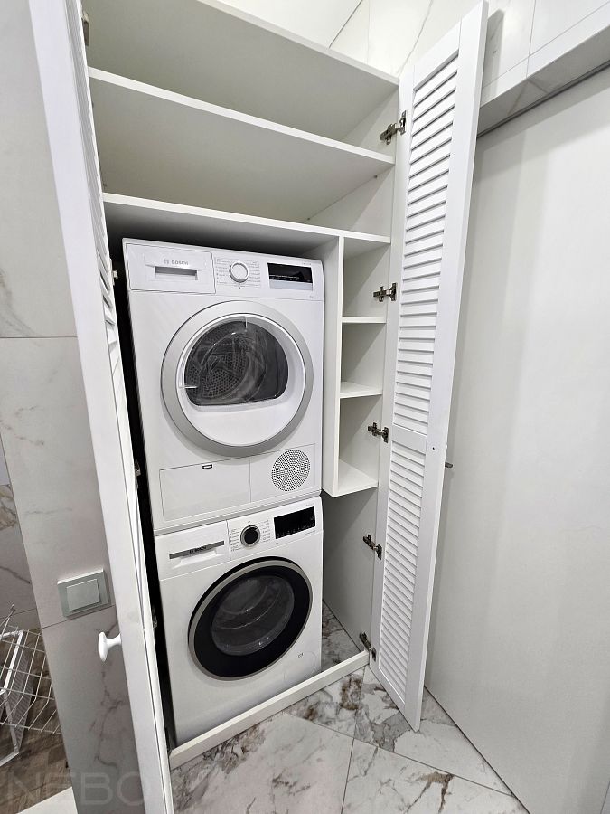 Белый жалюзийный шкаф для стиральной и сушильной машины в колонну в нише в ванной