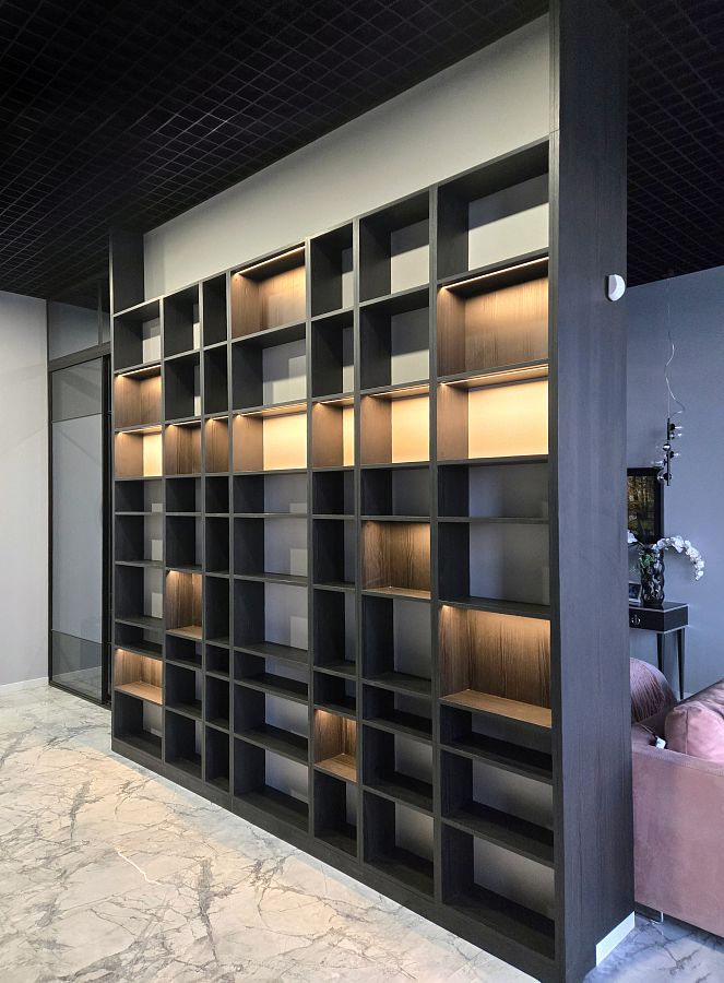 Огромный стеллаж со встроенной подсветкой для зонирующей перегородки между прихожей и гостиной
