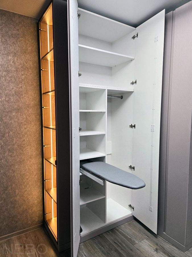 Угловой шкаф с выдвижной гладильной доской и витриной с подсветкой в спальню