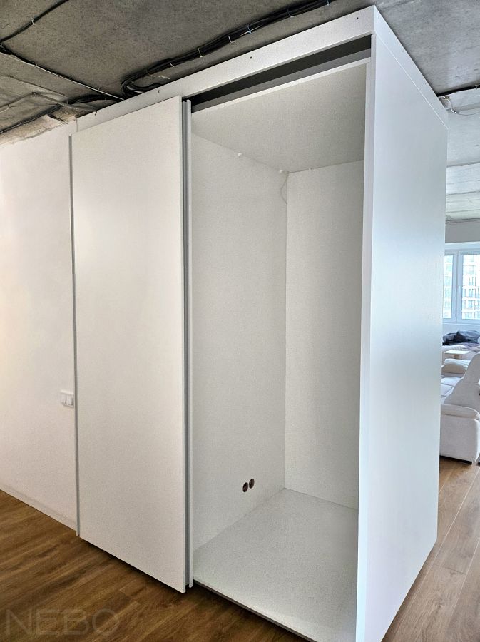 Компланарный шкаф-купе-перегородка между прихожей и гостиной с местом для хранения велосипедов 