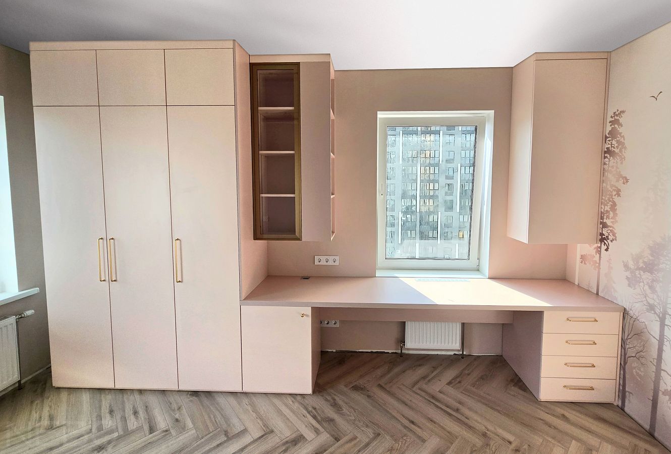 Нежно-розовая мебель в детскую комнату девочки со столом у окна и шкафом для одежды