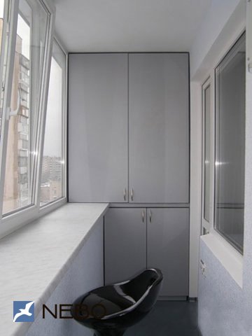 Встроенные распашные шкафы серого цвета для лоджии с широким подоконником-столешницей и барным стулом