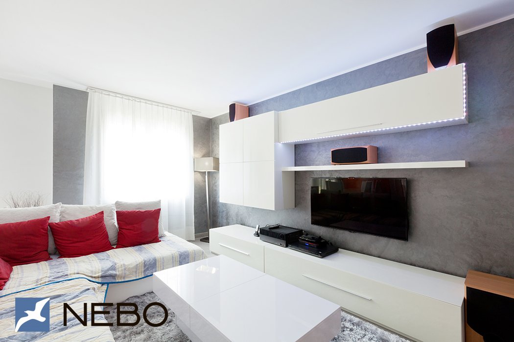 Белая гостиная мебель с минималистичными длинными ручками и подсветкой верхнего распашного шкафчика