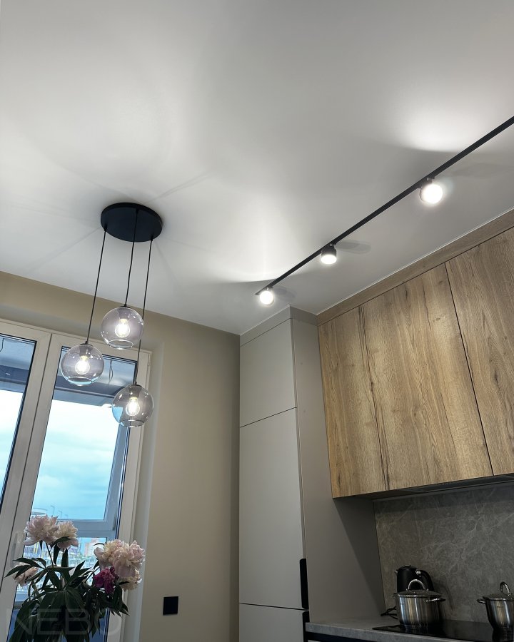Натяжной потолок общий для кухни и прихожей с черной трековой системой и спотовым освещением 