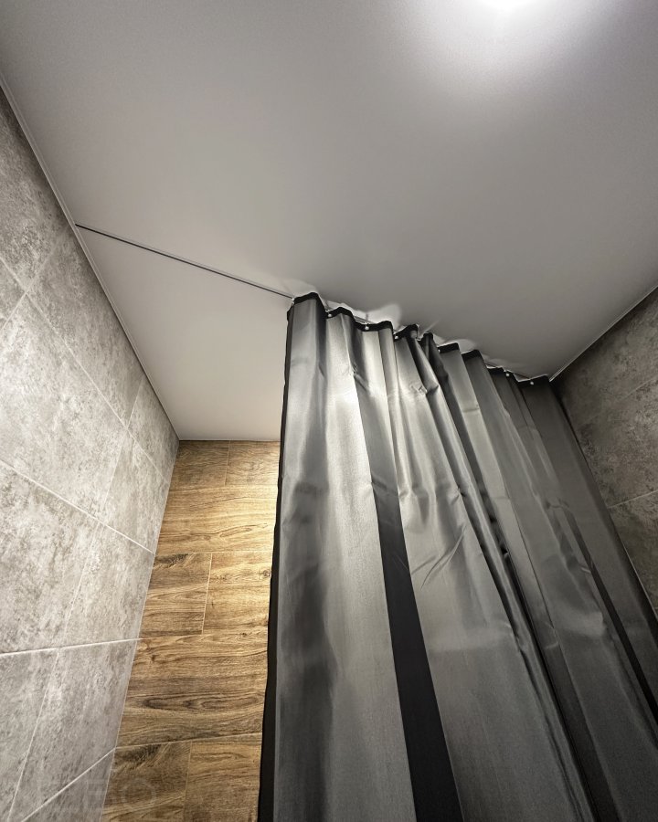 Натяжной потолок со встроенным карнизом для шторки в ванной комнате