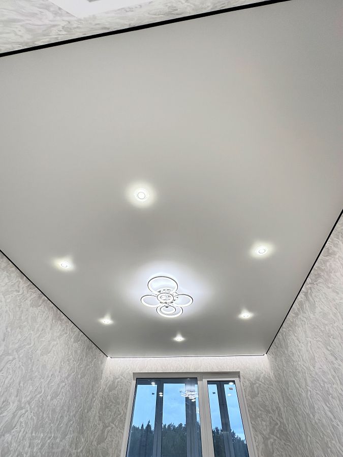 Натяжной потолок в детскую комнату с хорошим освещением и черной заглушкой по периметру