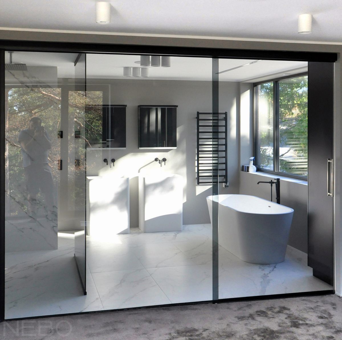 Стеклянная перегородка с раздвижной дверью вместо стены для зонирования ванной в частном доме