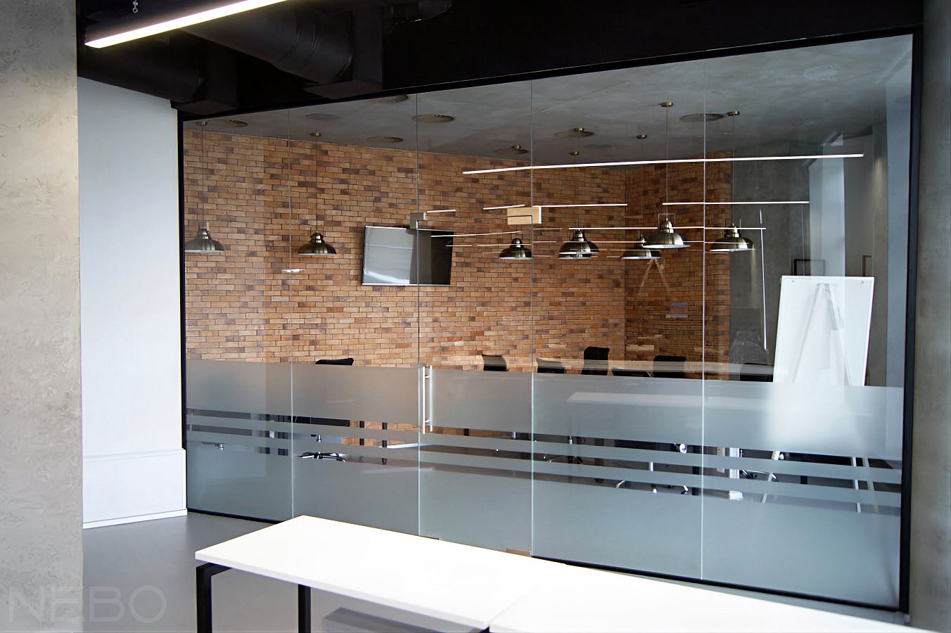 Цельностеклянная перегородка с маятниковой дверью вместо стены в офисе