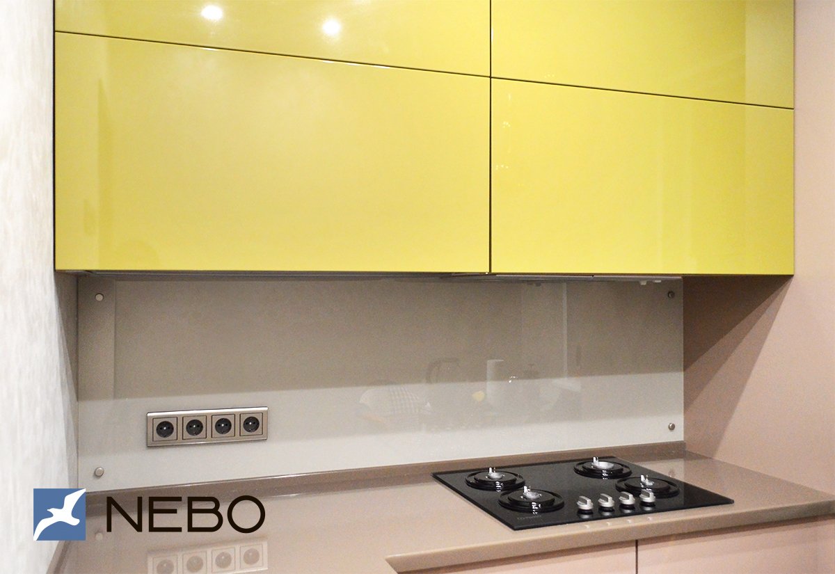 Стеклянный фартук светлого серо-коричневого цвета для кухни с желтыми верхними фасадами