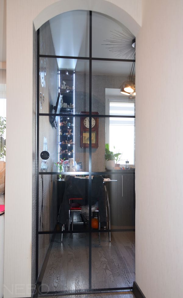 Стеклянная раздвижная дверь на кухню с черной фурнитурой и черными декоративными разделениями
