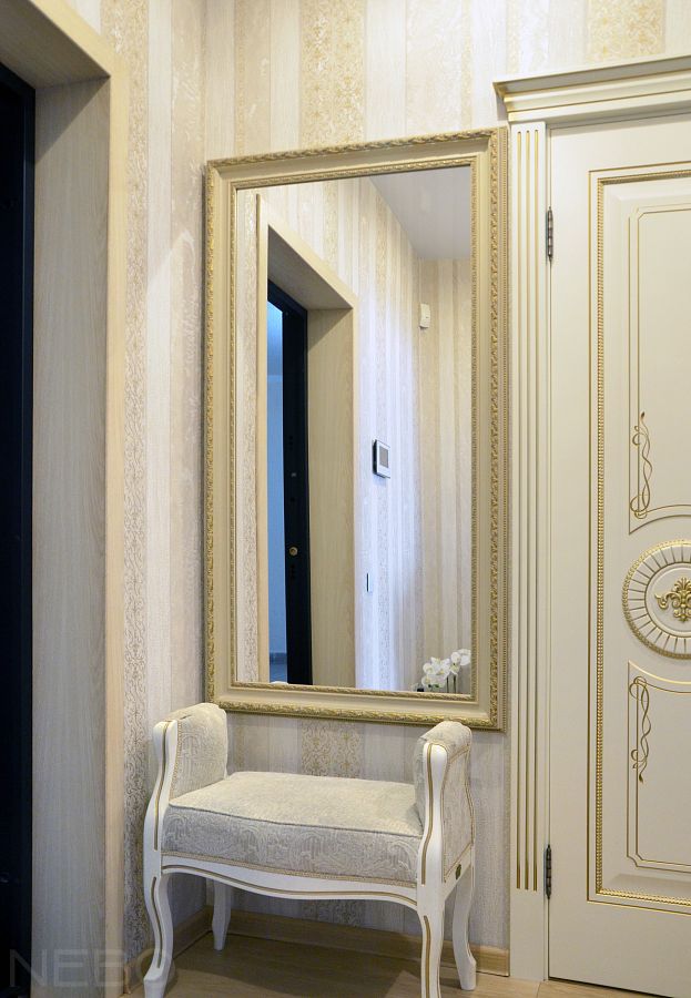 Прямоугольное зеркало в багетной раме над банкеткой в прихожей в классическом стиле