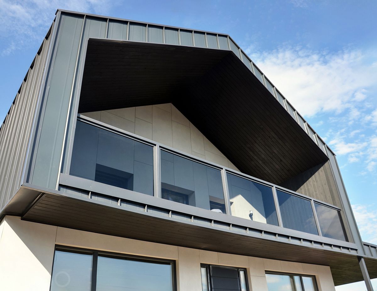 Ограждение террасы на втором этаже из стекла графит в зажимном профиле в проёмах металлокаркаса