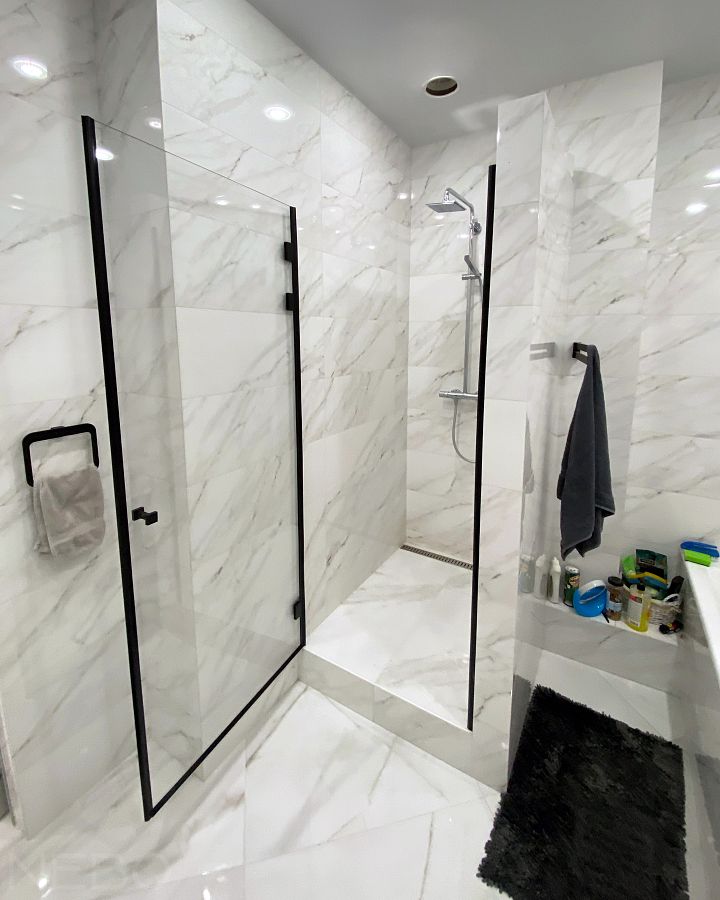 Распашная душевая кабина с одной дверью из осветленного стекла с черной фурнитурой и черными уплотнительными профилями