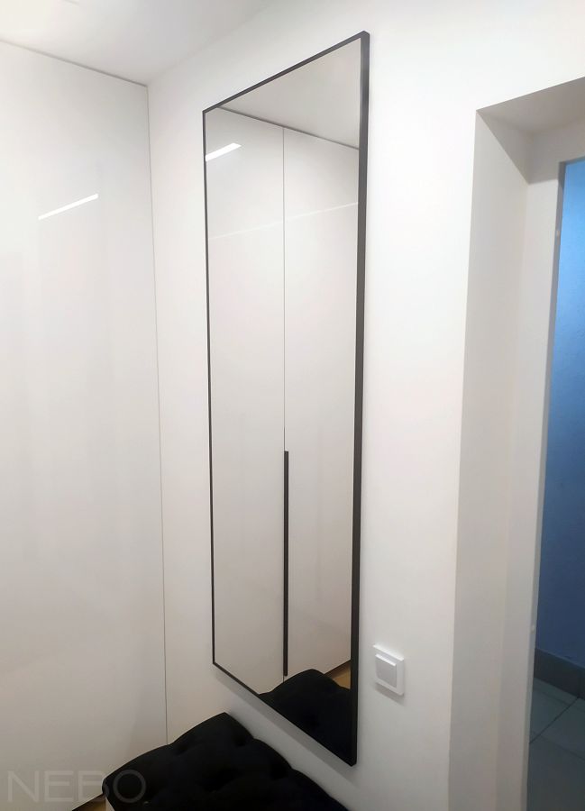 Навесное зеркало в черной алюминиевой раме для прихожей над мягким сиденьем возле входной двери