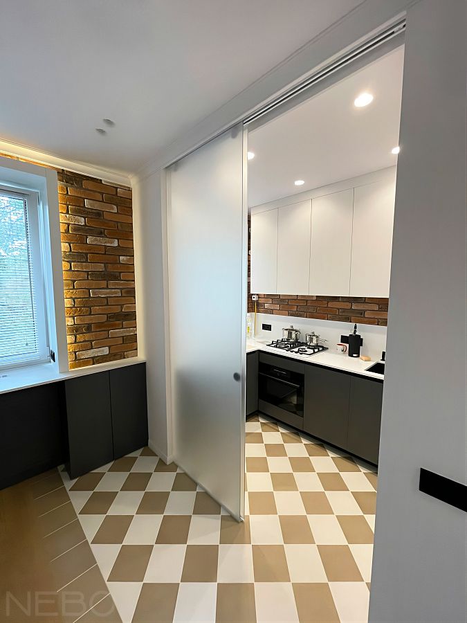 Стеклянная перегородка с раздвижной дверью для разделения гостиной и кухни с газовой плитой