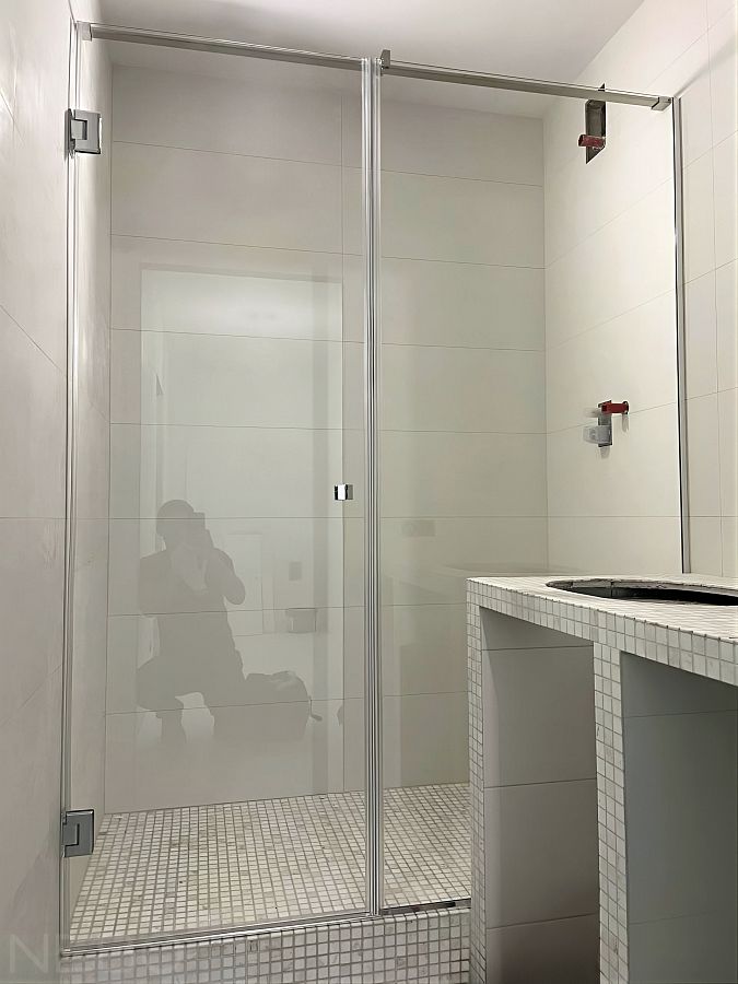 Стеклянная перегородка с дверью для душевой с установкой на подиум из мозаики