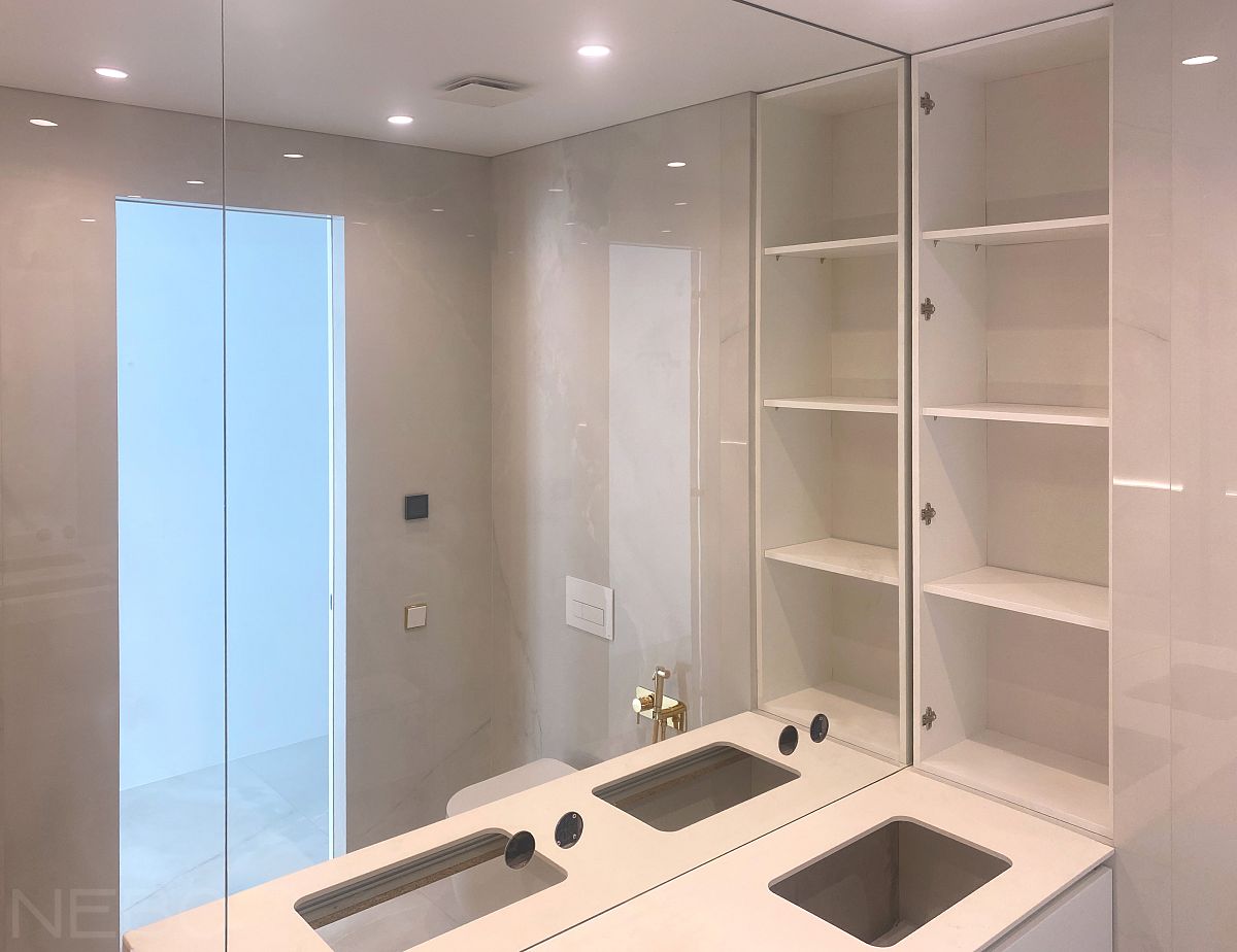 Зеркала во всю стену в ванной вокруг подвесной тумбы с вырезами под смесители