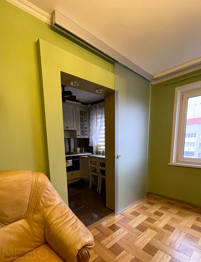 Раздвижная межкомнатная дверь из матового стекла между кухней и гостиной в квартире