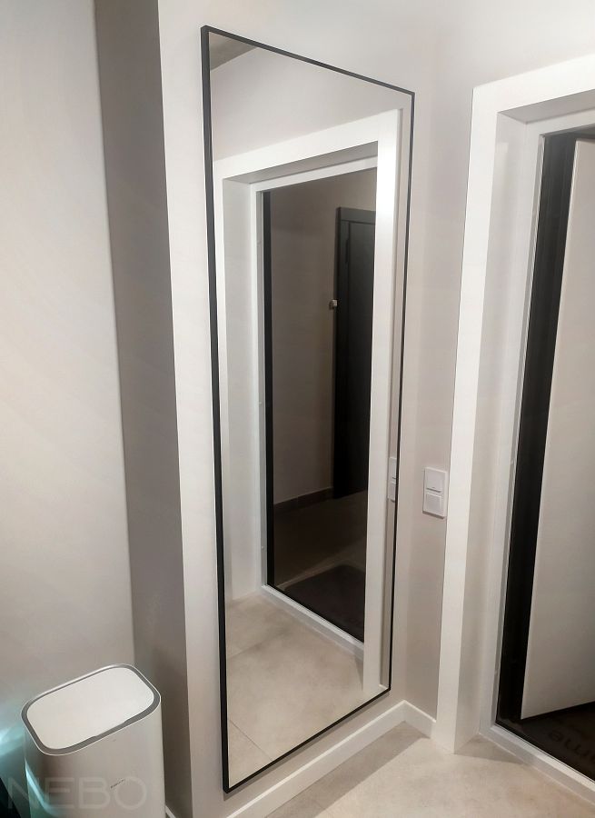 Зеркало в черной алюминиевой раме у входной двери в прихожей