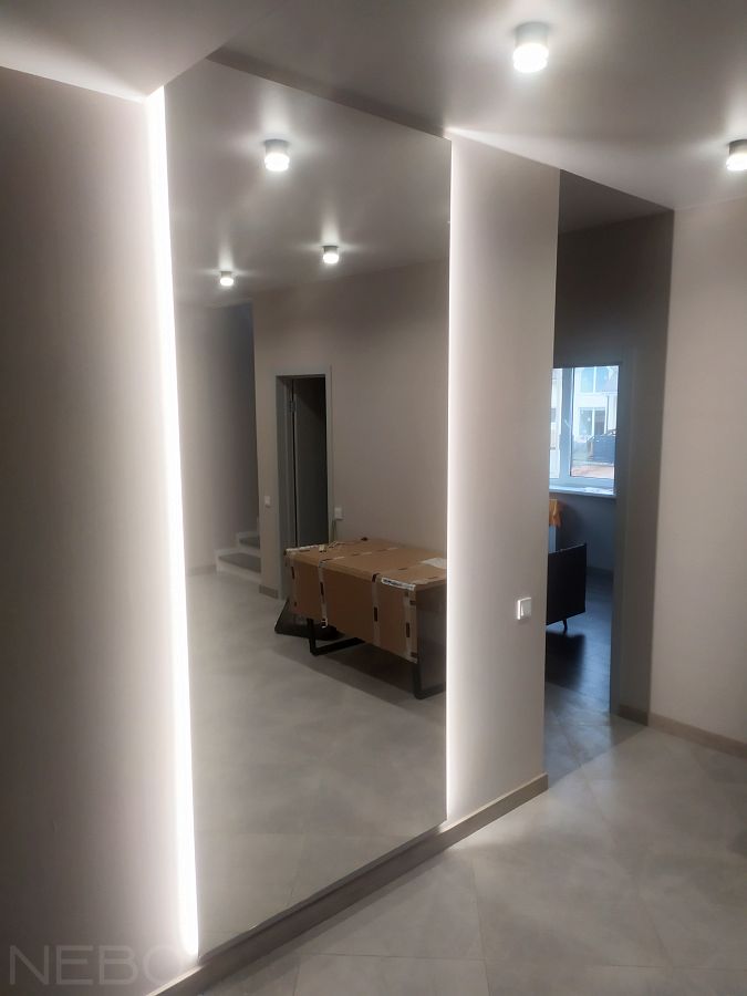 Большое зеркало от пола до потолка с парящей подсветкой по бокам в прихожую в  частном доме