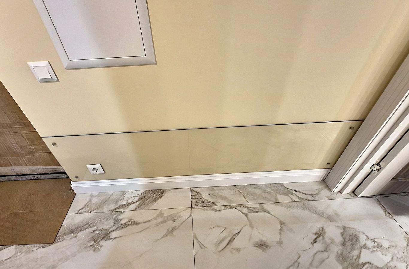 Защитное стекло на стену у пола в коридоре возле входной двери