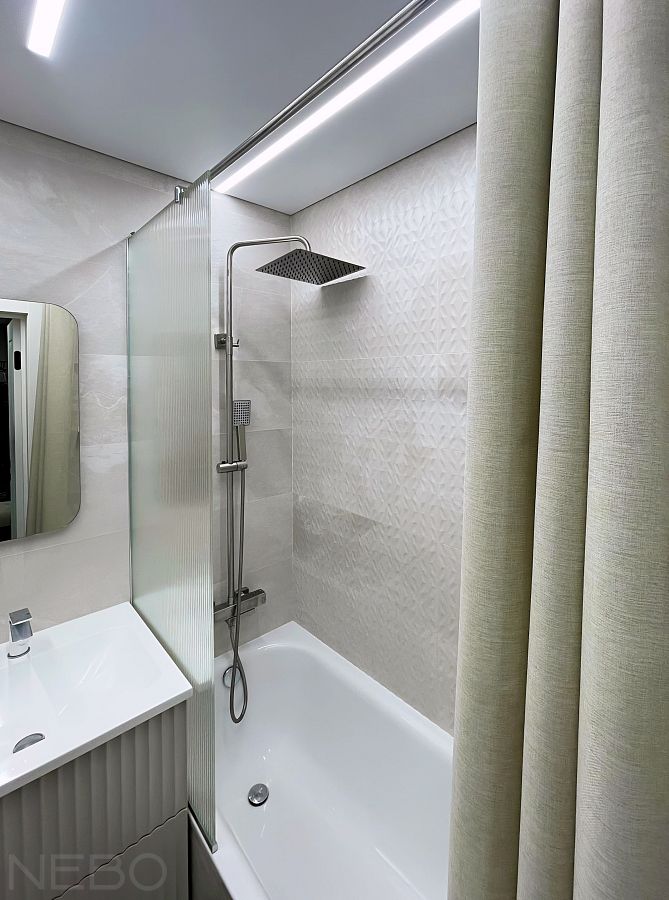 Перегородка из рифленого стекла на ванну с длинной круглой штангой для раздвижной тканевой шторки