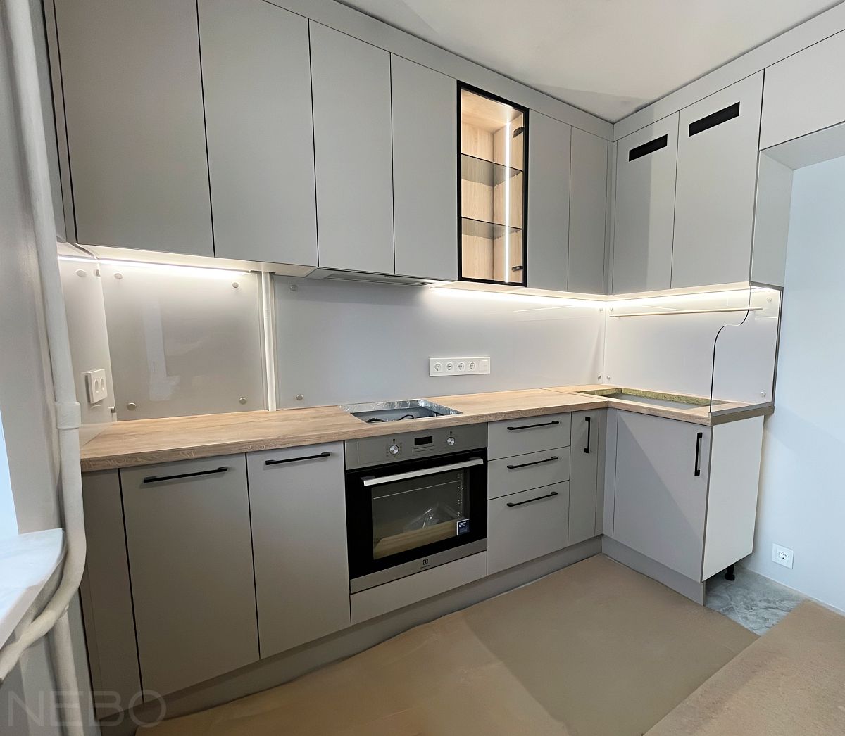 Светло-серый стеклянный фартук для серой кухни до потолка