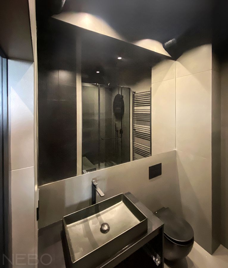 Большое зеркало встроенное в плитку над раковиной и инсталляцией в ванной комнате 